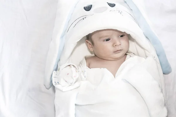 Schattig schattige pasgeboren babyjongen op witte achtergrond. Het mooie kind droeg een kostuum konijn met lange oren. Vakantie, Pasen. — Stockfoto