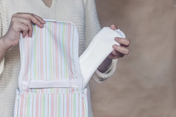 Women hold a menstrual pad. Young woman taking out a sanitary pad from her bag. White menstrual pad