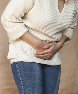 Genç kadın acı bir mide ağrısı sahip. Kronik gastrit. Karında şişkinlik ve sağlık kavramı
