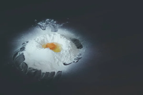 Яичный желток на муке. Куча белой муки и яйцо. Выпечка ингредиентов на деревянном столе. Разбитое яйцо на муке . — стоковое фото