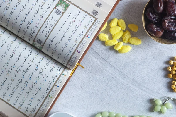 Holy Quran, Rosary, Iftar sweets and dried fruits with a cup of water. View from above. Flat lay photo — Stock Photo, Image