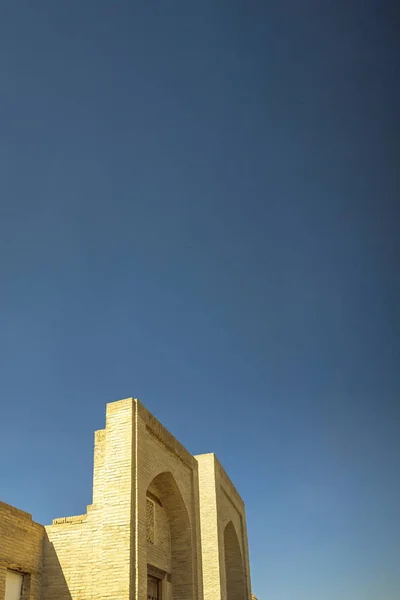 Vertikale Ansicht eines alten Backsteingebäudes. antike Gebäude des mittelalterlichen Asiens. Buchara, Usbekistan — kostenloses Stockfoto