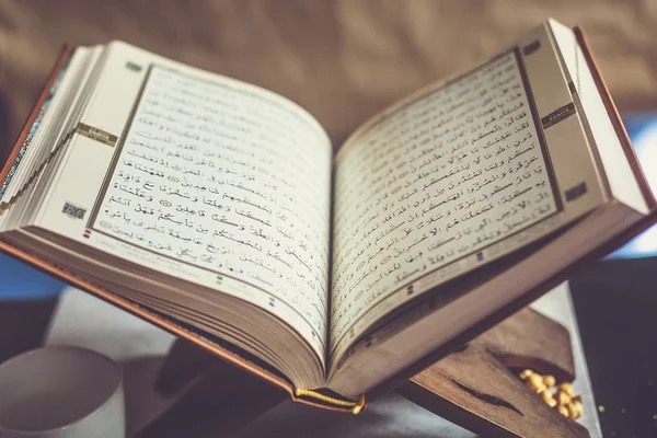 Quran - heiliges Buch auf Büchertisch Stockbild