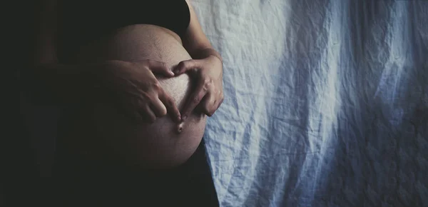 Mulher grávida no nono mês mostrando coração com as mãos — Fotografia de Stock