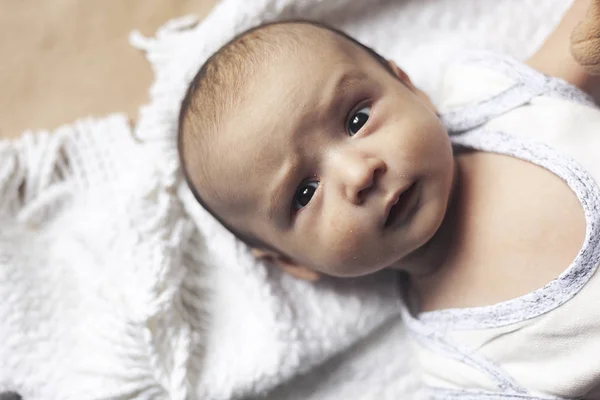 Bébé garçon de 2 mois mentant. Gros plan d'adorable nouveau-né mignon garçon de deux mois. Bébé au visage suspect. Sérieux gamin. Développement émotionnel chez les enfants . — Photo