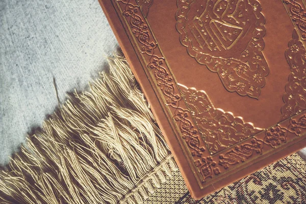 El Sagrado Corán sobre la alfombra de oración. Vista laica plana — Foto de Stock