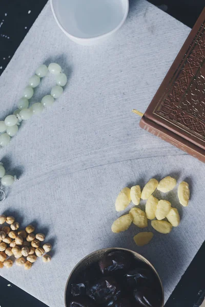 Священный Коран, Розарий, Ифтар сладости и сухофрукты с чашкой воды. Вид сверху. Плоская лежачая фотография — стоковое фото