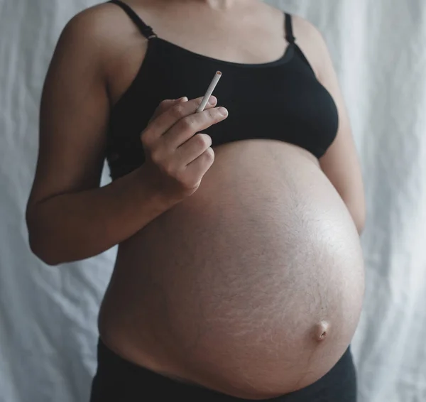 Pregnant woman smoking cigarette — Stock Photo, Image