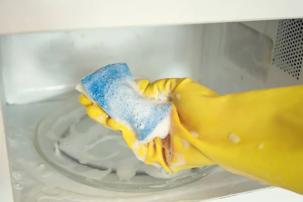Жінка руки в гумових рукавичках миття мікрохвильової печі — стокове фото