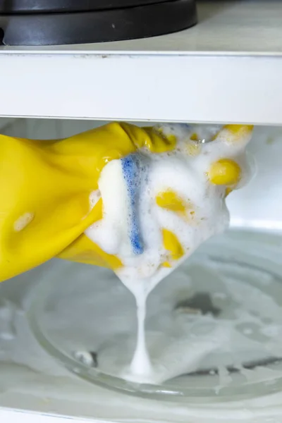 Mujer manos en guantes de goma lavando microondas — Foto de Stock