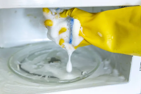 Woman hands in rubber gloves washing microwave — Stock Photo, Image