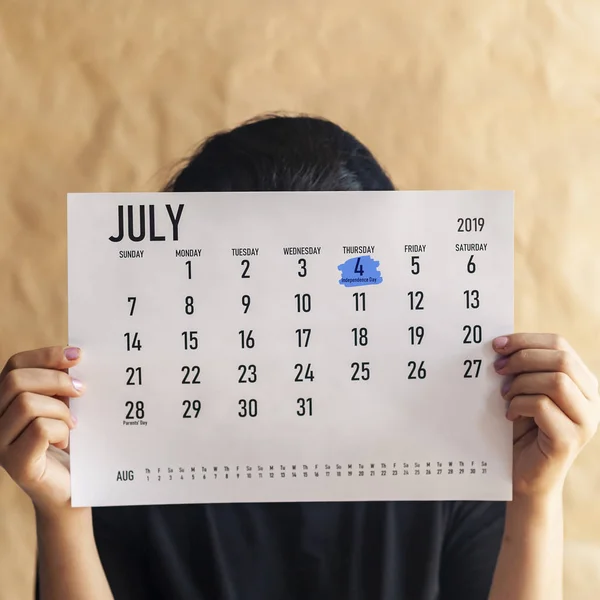 Frau hält Kalender mit markiertem Tag 4. Juli 2019 - uns Unabhängigkeitstag Stockfoto