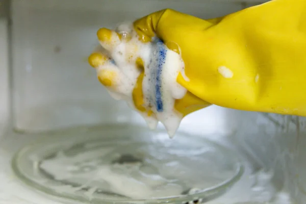 Žena ruce v gumových rukavicích mytí mikrovlnná trouba — Stock fotografie