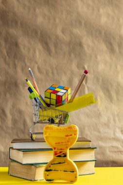 Okul konseptine geri dönelim. Alışveriş sepetinde okul malzemeleri ile kitap yığını