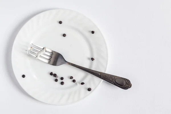 Töm smutsig vit plåt och gaffel på den vita bakgrunden. Smutsig tallrik med bitar och smulor dessert — Stockfoto