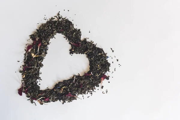 Forma do coração feita com uma mistura de uma variedade de folhas de chá secas — Fotografia de Stock