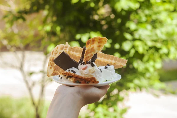 Wanita muda memegang es krim lezat dengan wafel selama piknik di alam. Konsep makanan musim panas. Pemuda dewasa makan es krim yummy dengan tongkat pada hari musim panas yang cerah . — Stok Foto