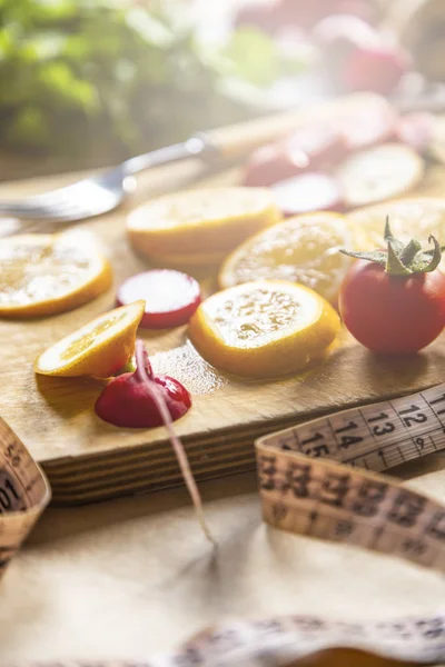 Latar belakang makanan vegan sehat dengan potongan papan dan irisan lemon. Tampilan atas ke latar belakang makanan organik dengan potongan papan dan irisan lemon — Stok Foto