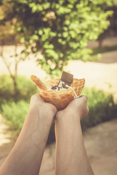 Wanita muda memegang es krim lezat dengan wafel selama piknik di alam. Konsep makanan musim panas. Pemuda dewasa makan es krim yummy dengan tongkat pada hari musim panas yang cerah . — Stok Foto