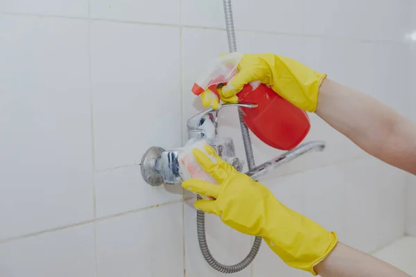 Ama de casa limpieza grifo de baño y ducha Grifo. Mucama en guantes protectores amarillos lavando grifo de baño sucio. Las manos de la mujer baño de lavado — Foto de Stock