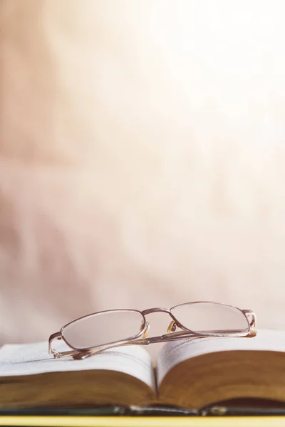 De vuelta al concepto escolar. Gafas en un libro. Libro abierto con gafas . — Foto de stock gratis