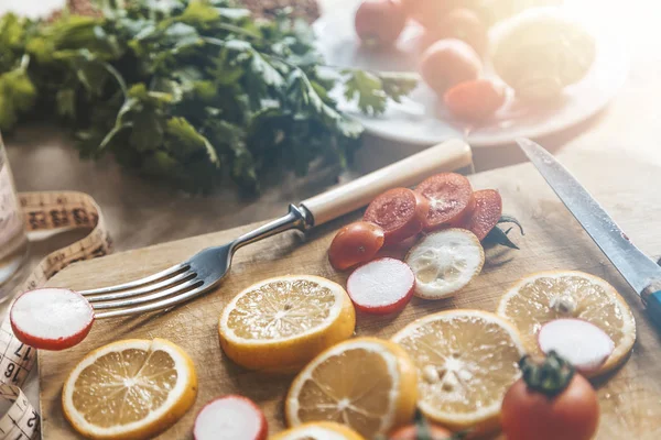 Fondo alimenticio vegano saludable con tabla de cortar y rodaja de limón — Foto de Stock