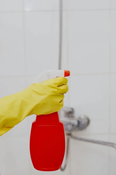 Жінка з розпилювачем. Домогосподарка тримає червону пляшку спрею у ванній. Чистка ванни — стокове фото