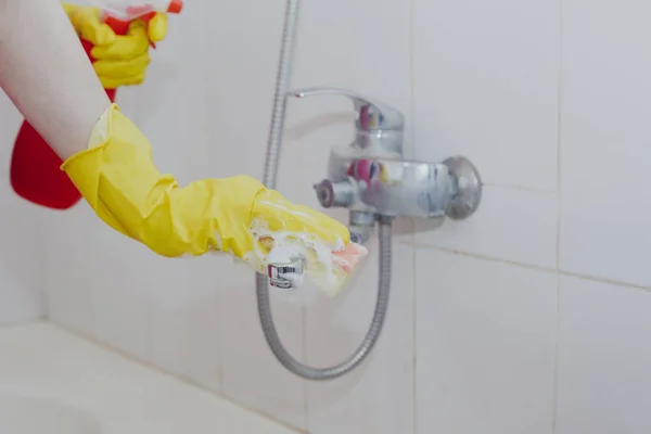 Ama de casa limpieza grifo de baño y ducha Grifo. Mucama en guantes protectores amarillos lavando grifo de baño sucio. Las manos de la mujer baño de lavado — Foto de Stock