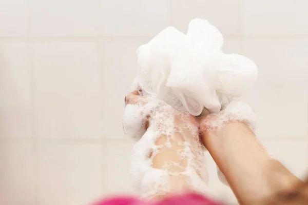 Mujer lavándose las manos con una esponja en el baño. Brazos de lavado femeninos con una esponja espumosa en el baño. Cuidado corporal y concepto limpio — Foto de Stock