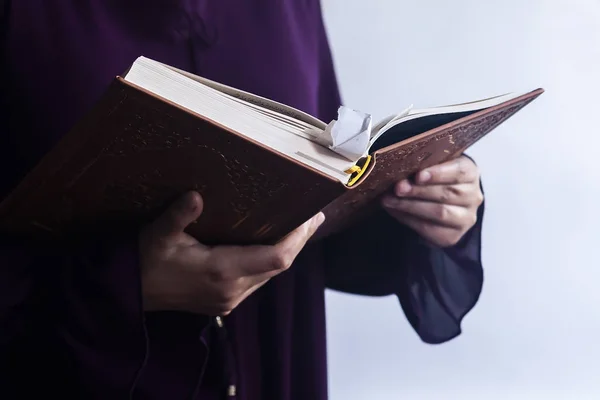 Молящаяся молодая мусульманка. Ближневосточная девушка молится и читает священный Коран. Мусульманка, изучающая Коран — стоковое фото
