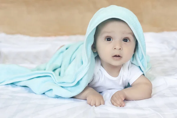 6-8个月大的男婴在床上玩着。迷人的6-7个月小婴儿在白色体衣。在白色床上用品的男婴。复制空间 — 图库照片