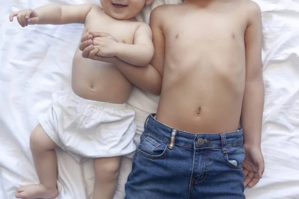 Happy childhood concept. Happy brothers portrait. 6 years and 6 months old boys having fun. Two little kids smiling having good time. Cute little brothers lying and playing together