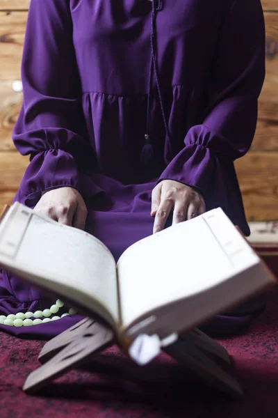 Praying young muslim woman. Middle eastern girl praying and reading the holy Quran. Muslim woman studying The Quran