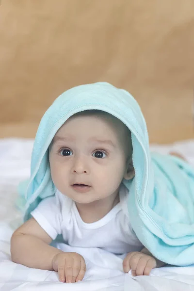 Menino de 6-8 meses deitado na cama. Encantador bebê de 6-7 meses de macacão branco. Menino de cama branca. Espaço de cópia — Fotografia de Stock