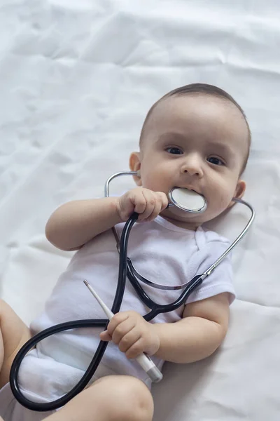 Little cute baby doctor. 6-month old baby boy playing with stethoscope. Kid having fun like a doctor — Stock Photo, Image