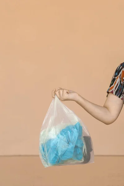 Full recycle bag. Female hanging white garbage bag. Plastic pollution waste concept. Free space