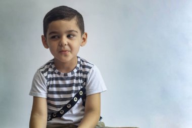 Altı yıllık çocuk portre. Gri arka planda masum gülümseyen küçük çocuk. Küçük çocuk yüzünü kontrol eder. İnsanlar, çocukluk yaşam tarzı kavramı.