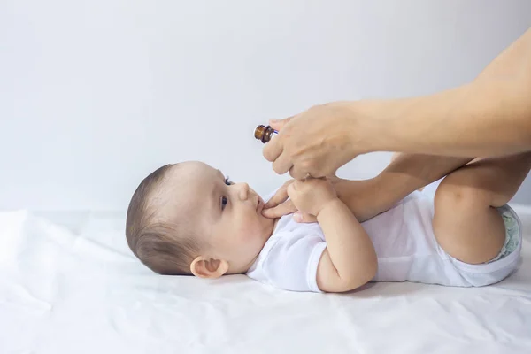 A doctor gives newborn baby rotavirus vaccine. Child immunization with little drop in clinic.Baby boy gets medicine from a little bottle — Stock Photo, Image