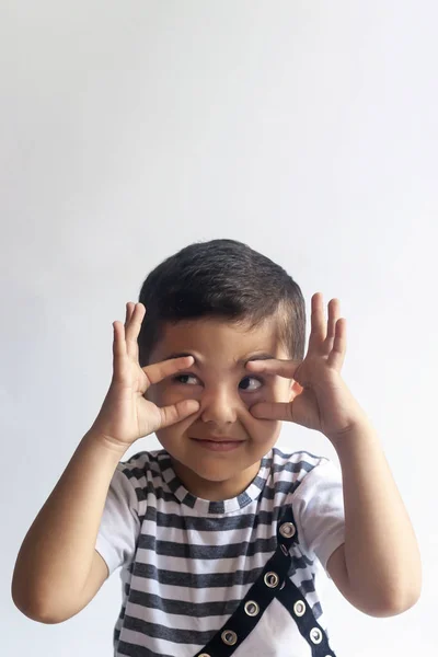 Retrato de niño de seis años. Niño inocente sonriente sobre fondo gris. El niño se retuerce la cara. Personas, concepto de estilo de vida infantil . — Foto de Stock