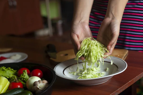 Ibu rumah tangga membuat salad dari sayuran segar yang sehat. Wanita muda membuat salad — Stok Foto