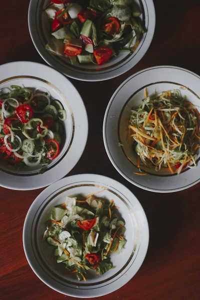 Várias saladas com verduras e verdes. Conceito de alimentação saudável. Produtos hortícolas mistos — Fotos gratuitas