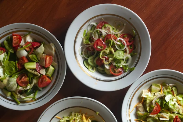 Várias saladas com verduras e verdes. Conceito de alimentação saudável. Produtos hortícolas mistos — Fotos gratuitas