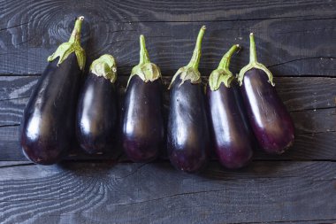 Ahşap arka planda taze topalmış çiğ patlıcan