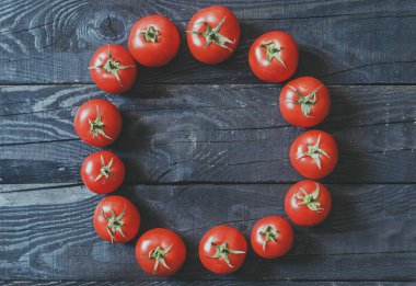 Daire koyu rustik ahşap arka plan üzerinde taze toplenmiş domates ile oluşan