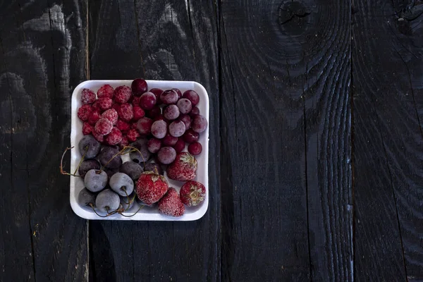 Frutas frescas congeladas caseras. Postres dulces saludables en madera rústica oscura . — Foto de Stock