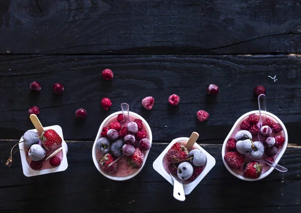 Hemlagad färsk yoghurt. Hälsosam söt efterrätt på mörkt rustikt trä. Frysta frukter — Gratis stockfoto