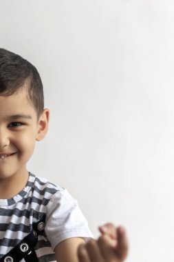 6 yaşındaki sevimli çocuğun yüzünün yarısı. Küçük çocuk işaret parmağıyla birini arıyor. Boş alan