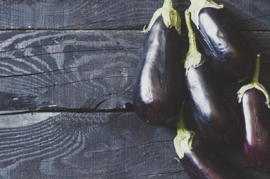 Ahşap arka planda taze topalmış çiğ patlıcan