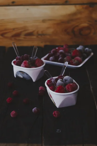Hausgemachter frischer Joghurt. gesundes süßes Dessert auf dunklem, rustikalem Holz. gefrorene Früchte — Stockfoto