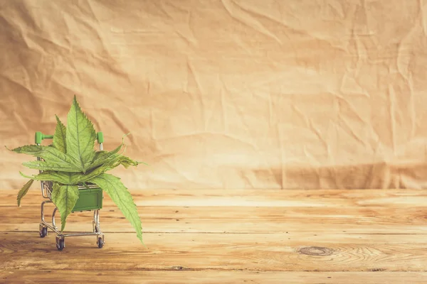 Cannabisblätter in den Warenkorb. Drogeneinkauf, Marihuana-Legalisierung, Drogengeschäftskonzept — Stockfoto